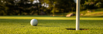 golfbal op green bij cup