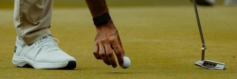 golfer die golfbal op green plaatst
