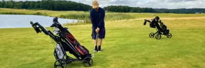 golfer met golftrolley op golfbaan
